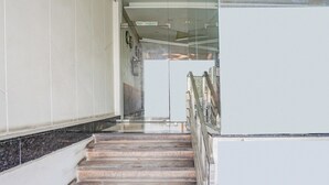 Una escalera con barandilla que lleva a una plataforma con una división de vidrio.