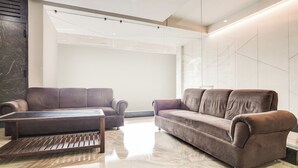Una sala de estar moderna con dos sofás, una mesita de centro y un piso de mármol.