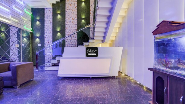 Ein Empfangsbereich mit modernem Design, inklusive einer Rezeption, einer Treppe und einem Aquarium.