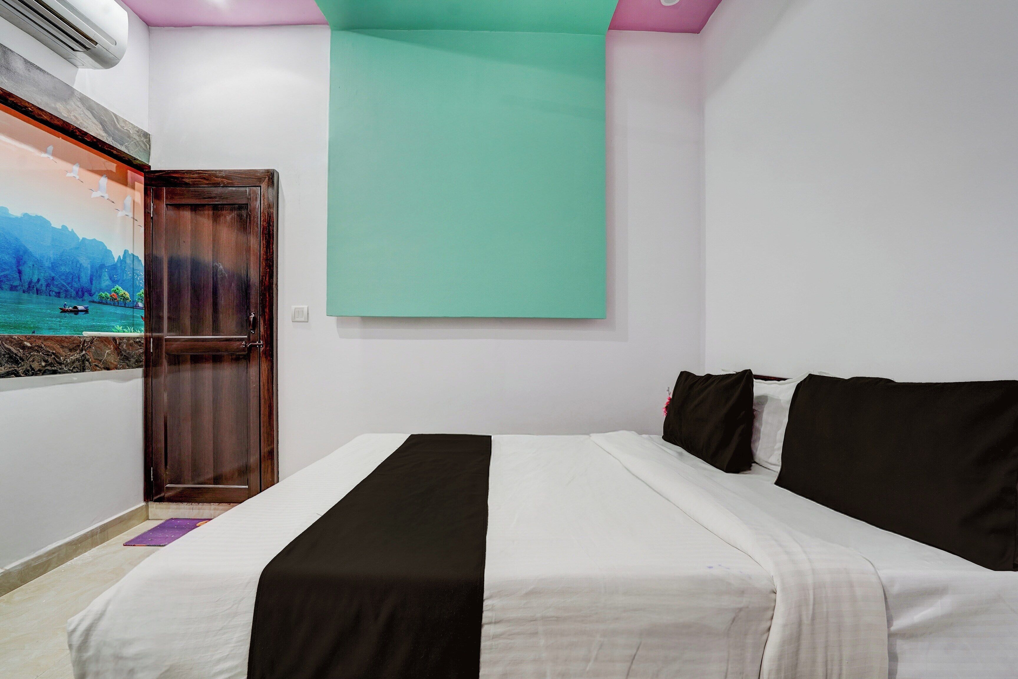Un dormitorio con cama, una puerta y un aire acondicionado instalado en la pared.