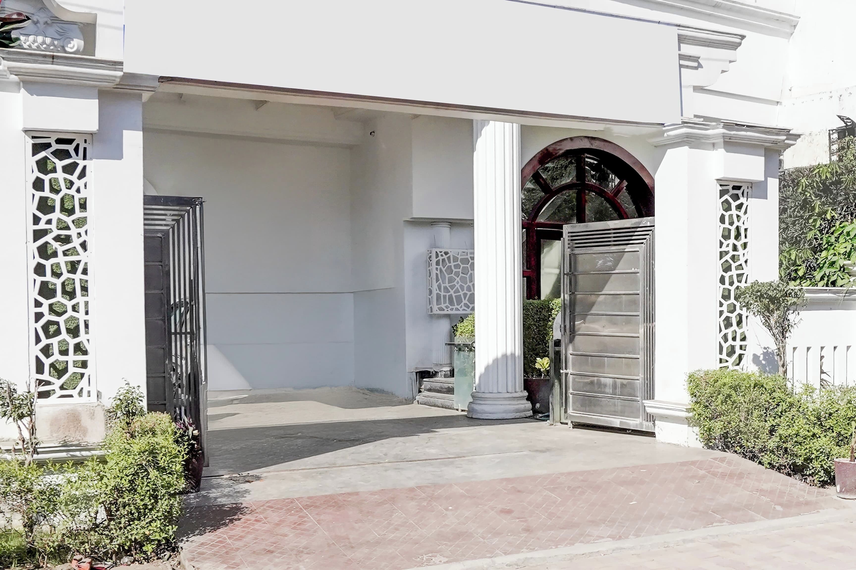 Un edificio blanco con una entrada porticada, un porche cubierto y un arco decorativo.