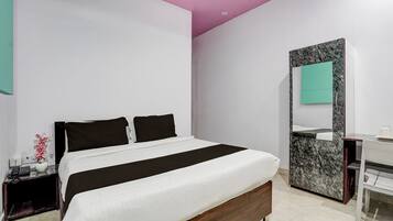 Un dormitorio moderno con cama, mesita de noche, espejo y tocador de baño.