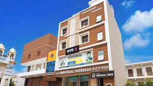 A multi-story building with signage for 'Universal Tower Hotel' and 'Oyo' services. - Collection O Rudrapur Bus Station (Rudrapur)