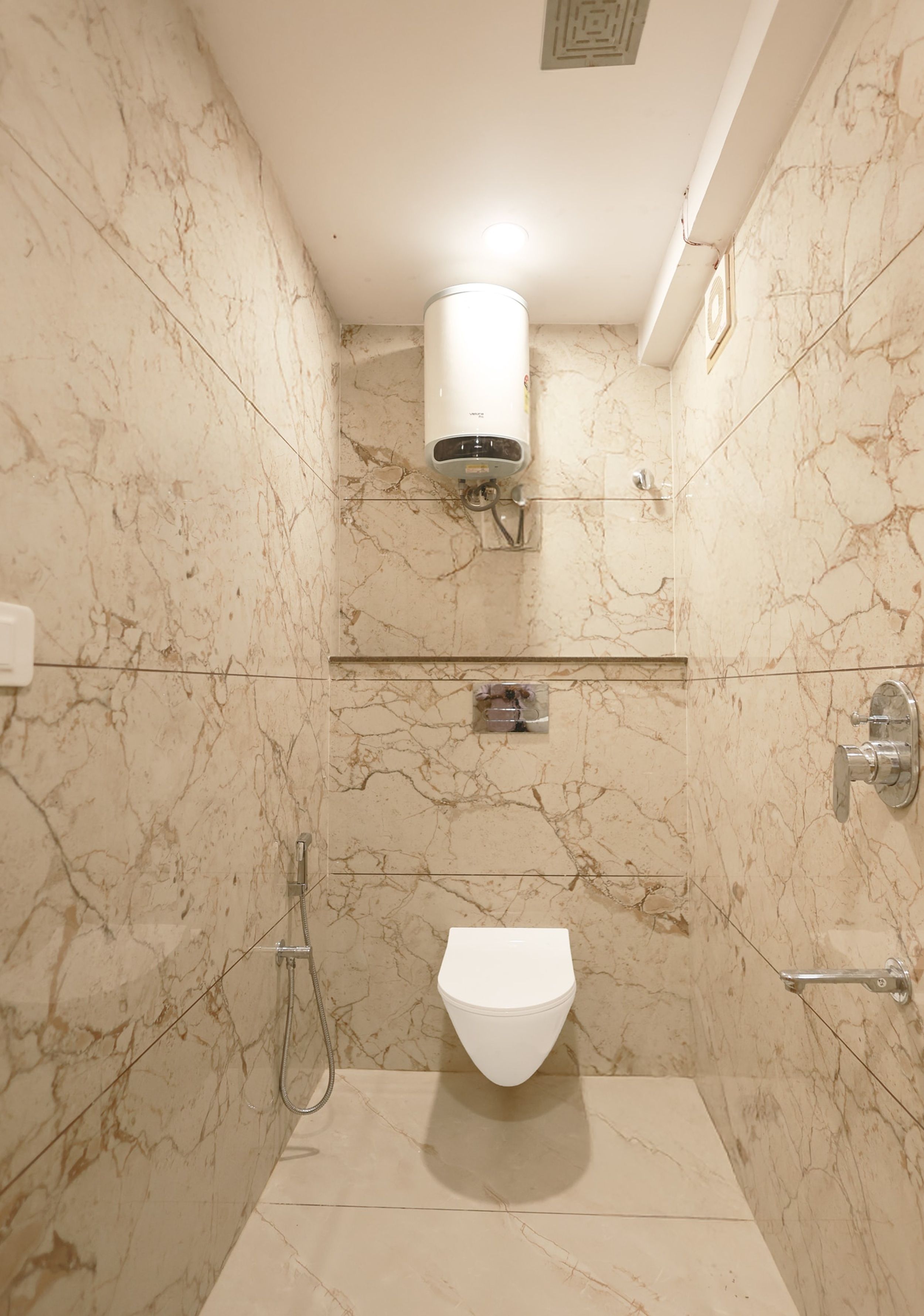 A bathroom with a toilet, a shower, and a hand dryer.