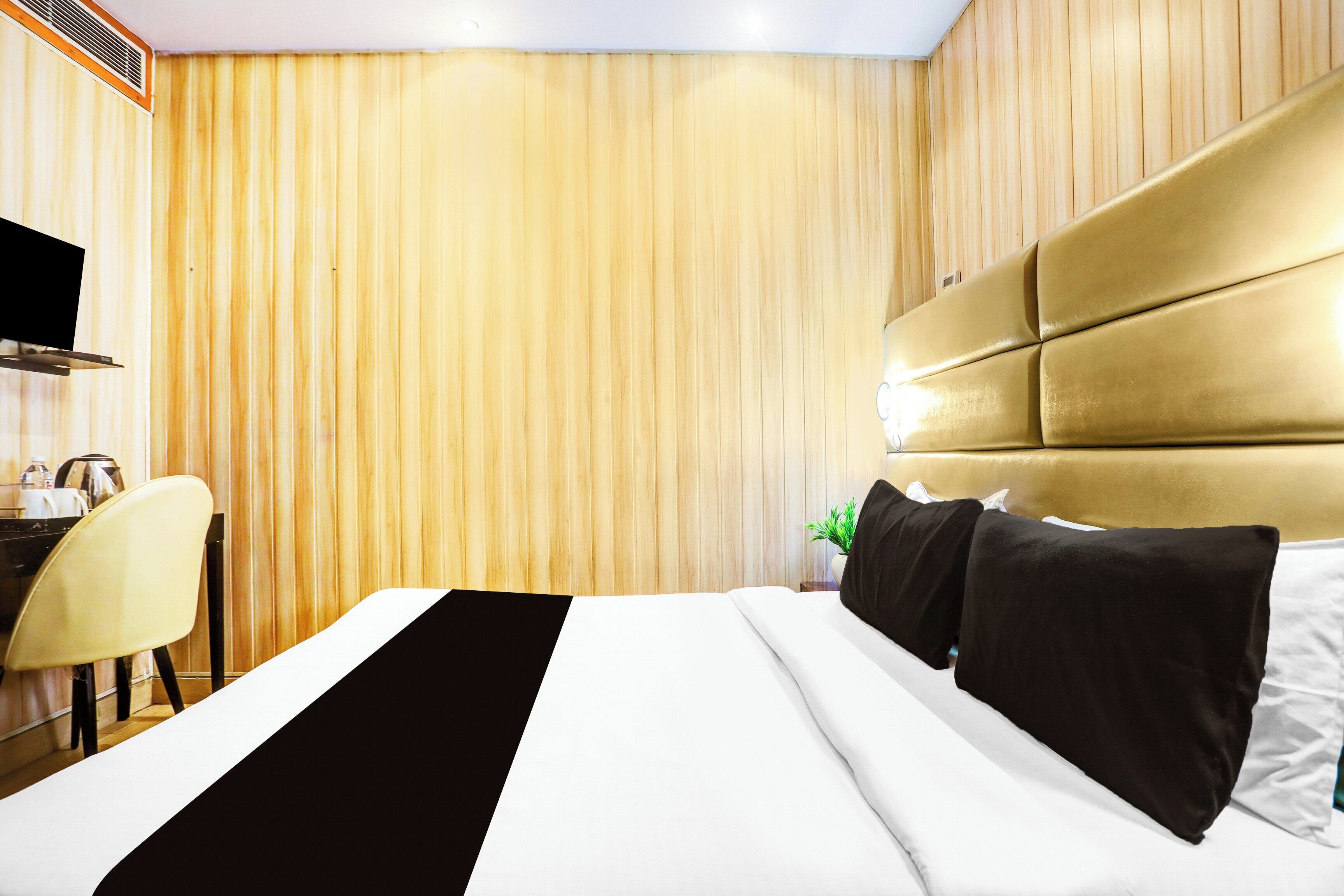 Une chambre d’hôtel avec un lit, un bureau et un téléviseur.