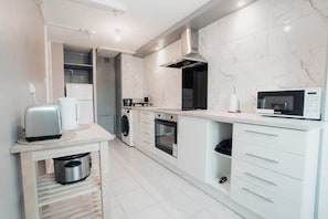 Eine moderne Küche mit Einbauofen, Mikrowelle und einer kleinen Essecke mit Toaster.