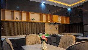 Una cocina moderna con comedor, que incluye una isla central, muebles de madera y una estufa integrada.