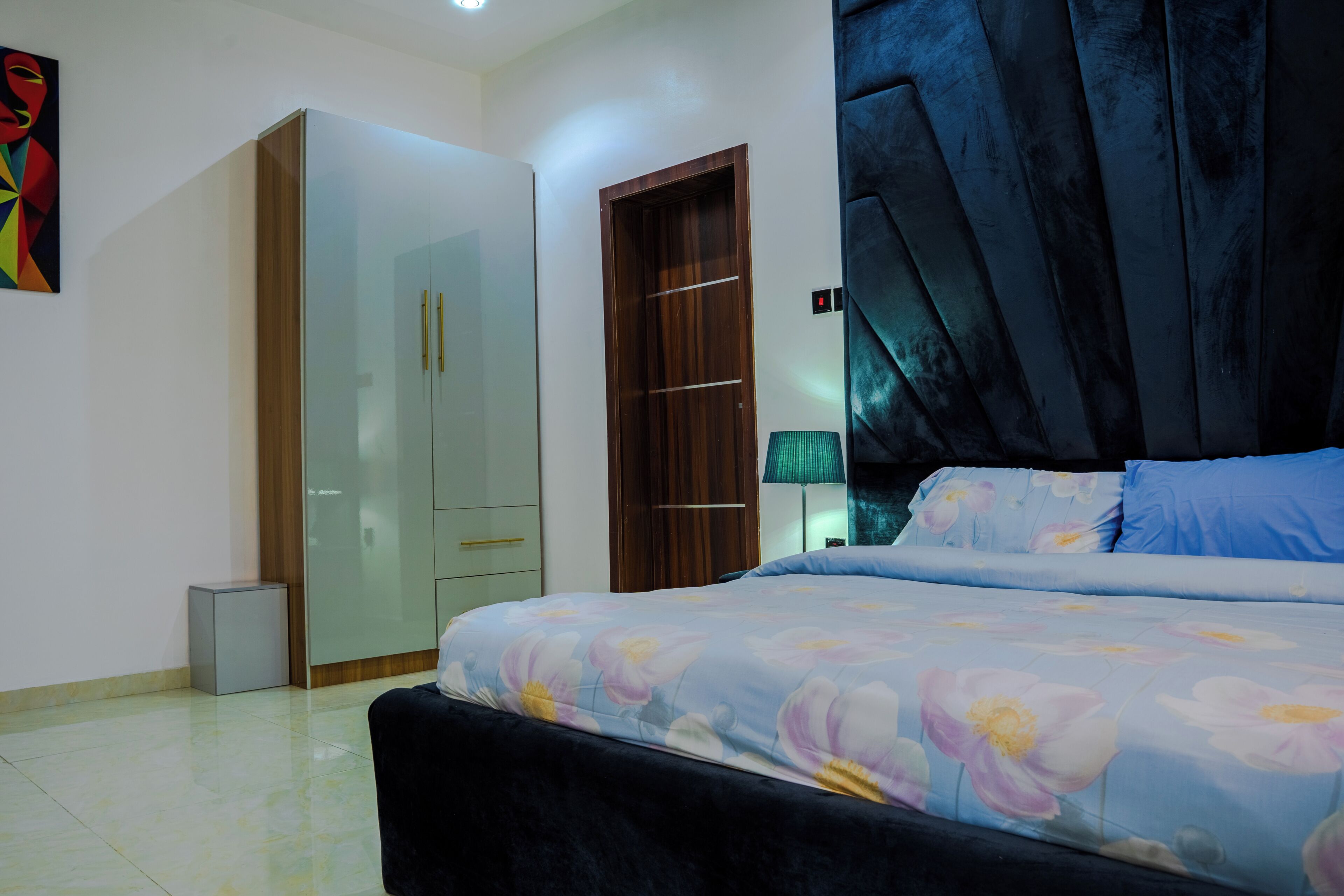 Una camera da letto con un letto, un armadio, uno specchio e una porta.