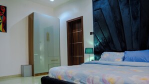 Un dormitorio con cama, armario, espejo y puerta.