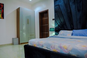 Un dormitorio con cama, armario, espejo y puerta.