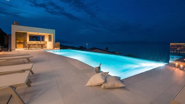 A modern outdoor pool area with a bar and seating. - Villa Rovni (Rasa)