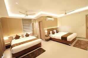 Quarto de hotel moderno com duas camas, um ventilador de teto, um ar condicionado e uma escada.