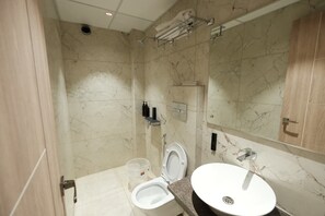 Un baño con inodoro, lavamanos y ducha.