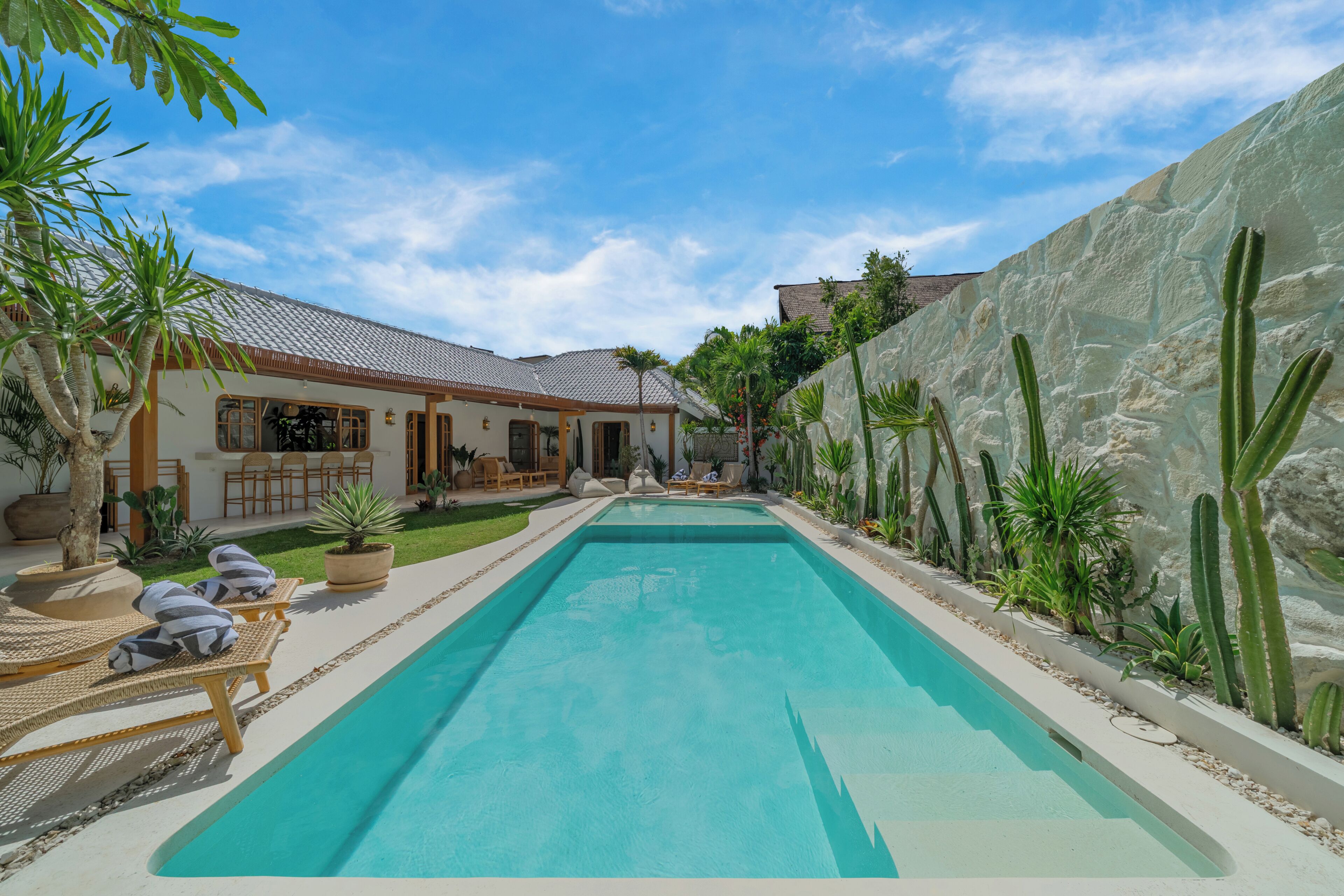 A swimming pool with lounge chairs and a patio area.