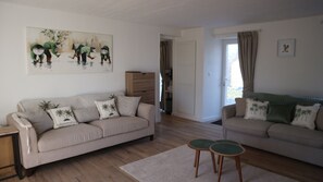 Een woonkamer met twee banken, een salontafel en een schilderij aan de muur.