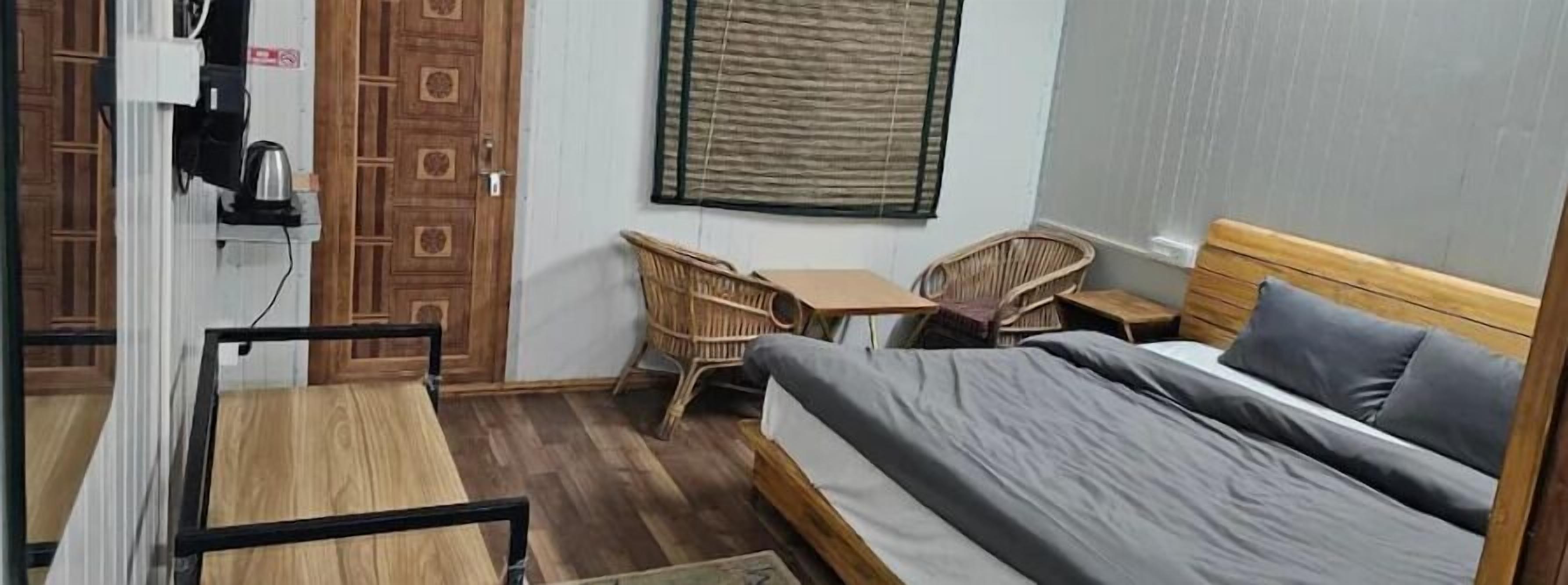 A room with a bed, a table, a chair, and a window.