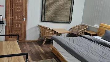 A room with a bed, a table, a chair, and a window.