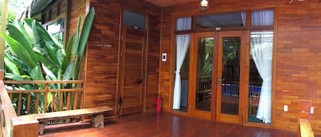 A wooden interior with a bench, a fire extinguisher, and a door marked 106B.