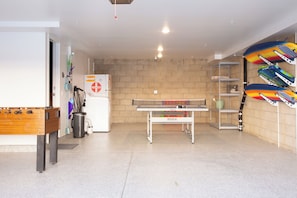 A room with a foosball table, a ping pong table, and a refrigerator. - NEW: Fun on 4th Encinitas (Aug 2026) rooftop fire pit (Encinitas)