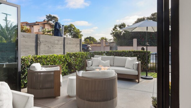 An outdoor patio area with a sofa, two chairs, and a round table. - NEW: Fun on 4th Encinitas (Aug 2026) rooftop fire pit (Encinitas)