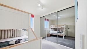 A room with bunk beds, a sliding door, and a view of the outdoors. - The Penthouse | Spa, Sauna, Gym, 360° Views, 4BR (Glenelg North)