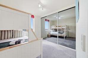 Ein Zimmer mit Etagenbetten, einer Schiebetür und Blick ins Freie.