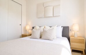 Una camera da letto con un letto, due comodini e due lampade a parete.