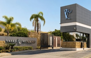 A hotel entrance with a sign reading 'Valle Romano' and a modern building with a logo. - Modern Apartment in Habitat Estepona (Estepona)