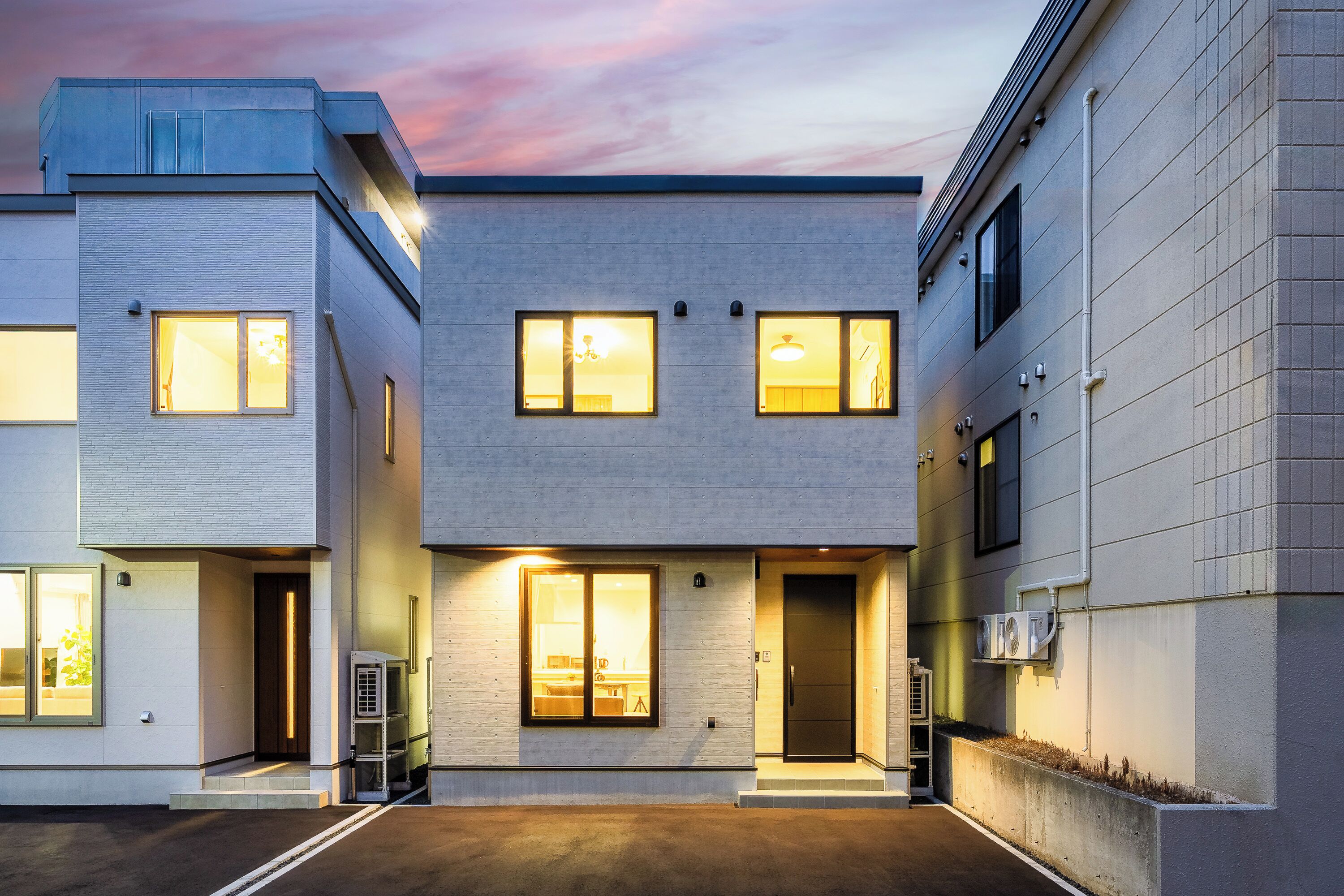 A modern building with a flat roof, multiple windows, and a central entrance.