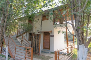 A building with a staircase, a wooden door, and a sign that reads 'MAYNA VILLA'.