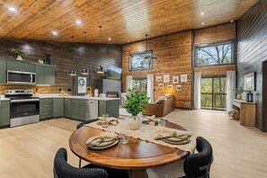 A modern kitchen with a built-in microwave, stove, and dark green cabinets. - Autumn Escape at Wears Valley • Hot Tub and Fireplace (Sevierville)