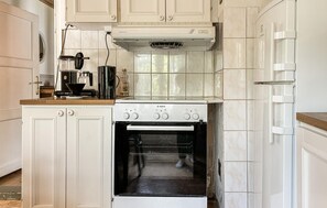 A kitchen with white cabinets, a Bosch oven, and a coffee maker.