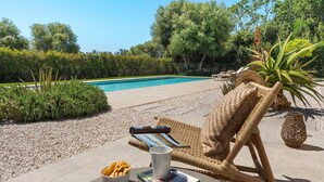 A poolside area with a lounge chair, a bowl of snacks, a magazine, and a cup. - Beautiful villa with private pool in Fontane Bianche - DiCasaInSicilia (Fontane Bianche)