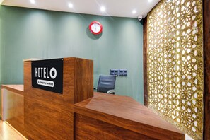Una recepción de hotel con un cartel que indica servicio de empresa.