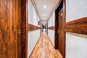 Un pasillo con puertas y piso de madera.