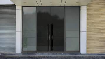 Une entrée de bâtiment moderne avec une porte en verre et un cadre métallique.