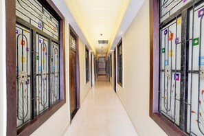 A hotel corridor with a tiled floor, decorative metal gates, and a ceiling with recessed lighting. - OYO Hotel O Subedarganj Railway Junction (Prayagraj)