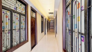 Um corredor com portas em ambos os lados, cada uma com grades metálicas decorativas.