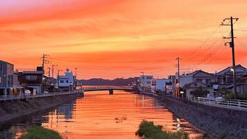 A calm river at sunset with buildings on either side.