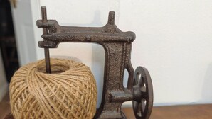 A vintage sewing machine with a ball of twine on a wooden surface. - Pinewood Cozy Apartment in Dundee (Dundee)