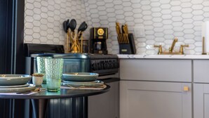 A kitchen with a round table set for dining, featuring plates, bowls, and a glass. - Whispering Pines A-Frame Retreat | Sleeps 2 | +AC (Ridgway)