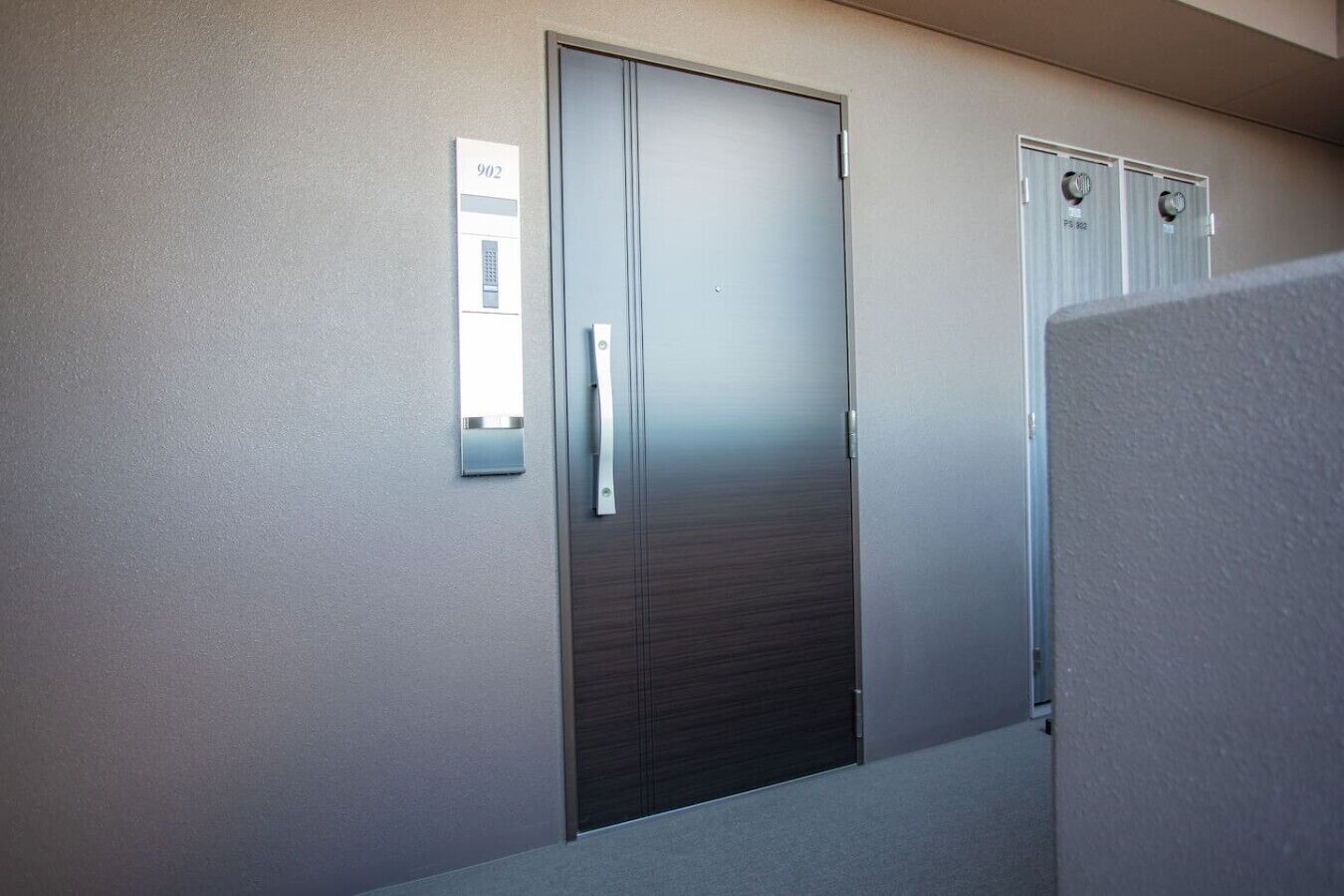 A modern elevator with a metallic handle and a digital display showing the number 902.
