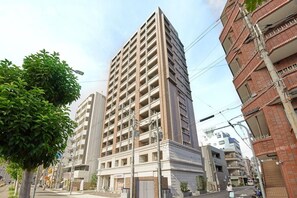A multi-story building with a flat facade, surrounded by other buildings and a street. - 1 min walk from sta./Excellent access to central (Osaka)