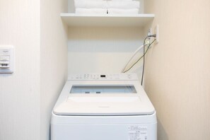 A front-loading washing machine with a control panel, a power outlet, and a towel rack above it. - 1 min walk from sta./Excellent access to central (Osaka)