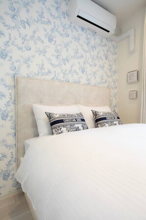 A bedroom with a bed, floral wallpaper, and two pillows with a brand name. - 1 min walk from sta./Excellent access to central (Osaka)
