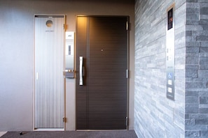 A hotel entrance with a double door, a digital elevator display, and a textured wall. - 1 min walk from sta./Excellent access to central (Osaka)