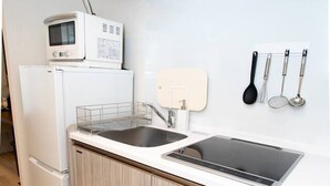 Ett modernt kök med inbyggd mikrovågsugn, en dubbel diskho och träskåp.