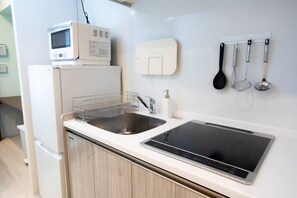 A modern kitchen with a microwave, sink, and induction cooktop. - 1 min walk from sta./Excellent access to central (Osaka)