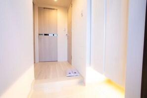 A narrow hallway with a wooden door at the end, a white wall, and a light switch on the wall. - 1 min walk from sta./Excellent access to central (Osaka)