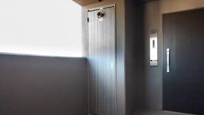 Un ascensor moderno con terminación metálica y una puerta con manija.
